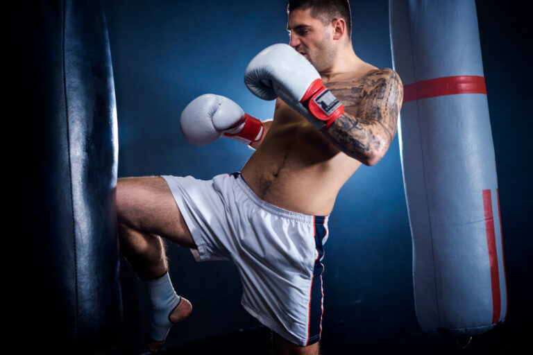 mężczyzna trenuje kickboxing na worku
